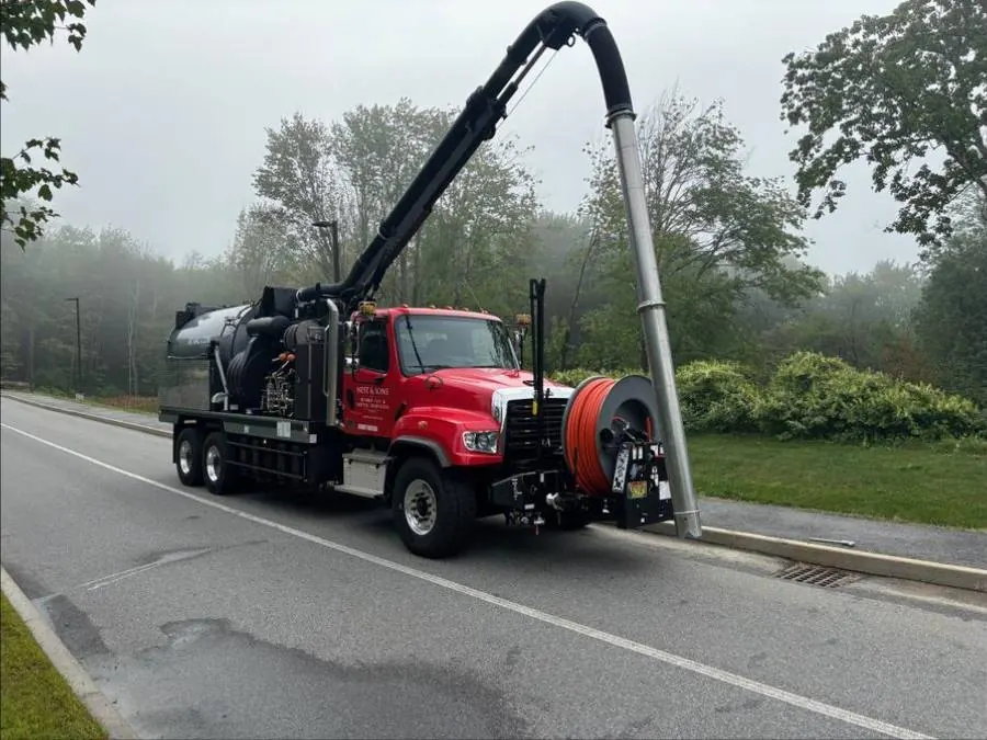 Nest and Sons hydrovac truck with boom extended on a Maine roadside